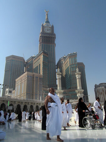 Zarándokok gyülekeznek a központi szentély, a Kaaba körül. Háttérben a világ legmagasabb toronyórája és a környező felhőkarcolók    (Fotó: Beta/AP )