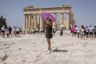 A woman takes a selfie in front of Parthenon temple atop of the ancient Acropolis hill during a heat wave in Athens, Greece, Friday, July 21, 2023. Heat in Greece is expected to grow worse d