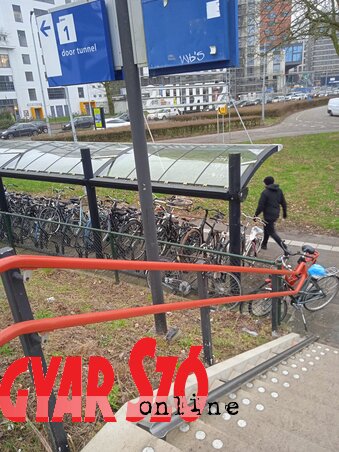 A vasútállomások, közintézmények közelében elmaradhatatlan a kerékpárparkoló. Ott, ahol lépcső is van, a korlát alá csatornára emlékeztető bádogkádat szerelnek, hogy azok is fel tudják tolni a bringát, akik már, vagy még nem képesek a hónuk alá kapni. (Fotó: Szeli Balázs)