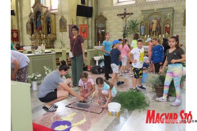 Gyerekek és felnőttek közösen készítették a virágszőnyegeket a moholi templomban (Csincsik Zsolt felvétele)