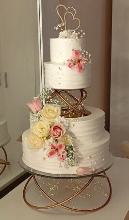 Tiszta szerelem és finom elegancia – ez a fehér, virágokkal díszített esküvői torta a különleges állvánnyal a romantika szimbóluma (Fotó: Huszta Henrietta archívuma)