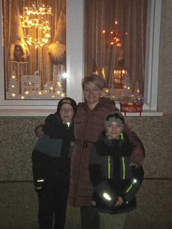 Rúzsa Lídia és két fia saját ablakuk előtt – ugyanis ők is díszítettek már az évek során (Fotó: Rúzsa Lídia archívuma)