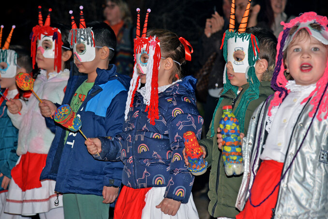 A gyerekek saját készítésű színes álarcokban
