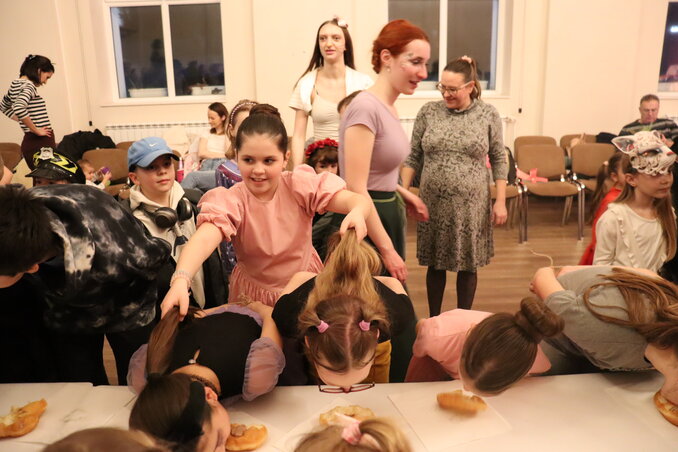 Egy kislány gondosan összefogja a versenyzők haját, hogy mindenki zavartalanul koncentrálhasson