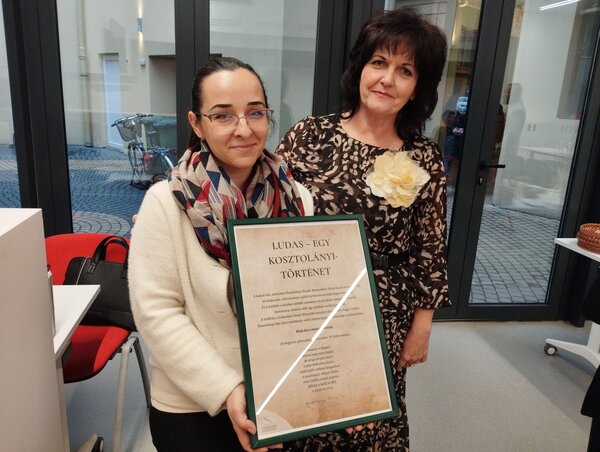 Homonaji-Szalai Andrea és Berényi Eszter a címpannóval