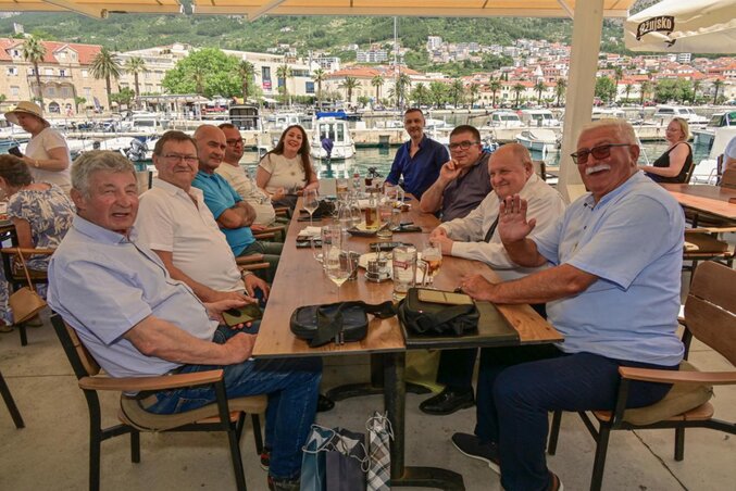 Balról: dr. Ivo Mravičić, Szolda József, Bognár Róbert (operatőr) a sor végén Marina Josipović. Jobbról az első Predrag Aranđelović, Valka Károly, Dejan Mijatović, a sor végén pedig Pető Attila, a Pannon RTV újságírója. A háttérben a Tučepi kikötő