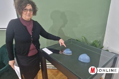 Szalma Viktóra az erededi Kerámia szívet mutatja, mellette látható a másolata (Fotó: Bartus Bella felvétele)
