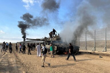 Palesztinok ünnepelnek egy kilőtt izraeli tank körül a Gázai-övezet határkerítésénél (Fotó: Reuters)