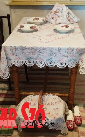 Étkezőasztal, előtte a ,,komatálat” tartalmazó, díszes kosár Étkezőasztal, előtte a ,,komatálat” tartalmazó, díszes kosár