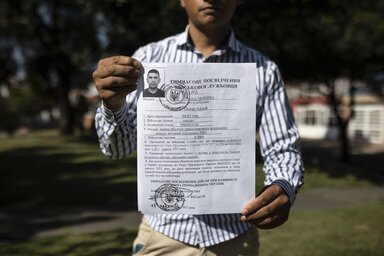 Ukrajnában zsoldosként több kolumbiai is harcol, vagy harcolt. A felvételen Oscar Arley Triana belépő papírjait tartja unokafivére, Diego Fernando Espitia Bogotában (Beta/AP)