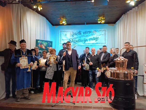 Dušica Marković átveszi Fábrik Attila főszervezőtől a bácskossuthfalvi pálinkaverseny legjobb italáért járó elismeréseket (Fotó: Kazinczy Paszterkó Diana felvétele)