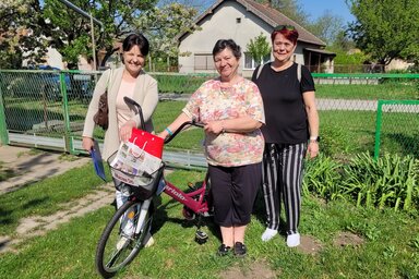 Szablyár Magdolna Ajándi Gabriella és Péter Edit az ajándék kerékpárral / Lakatos János felvétele