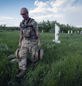 Ukrán katona aknákat távolít el egy temető közeléből Donyeck megyében (Fotó: Beta)