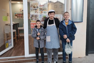 Libing Wang az étterem előtt két ifjú vendége társaságában (Kazinczy Paszterkó Diana felvétele)