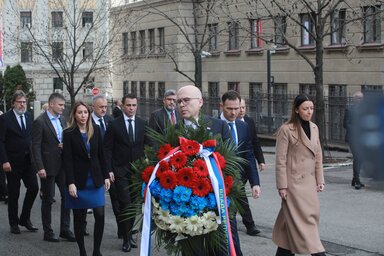 Miloš Vučević lemondásban lévő kormányfő és a miniszterek egy csoportja koszorút helyez el a kormányépület udvarában (Fotó: Beta)
