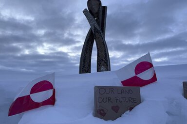 A grönlandi lobogók közé helyezett felirat (az önkormányzás kezdetét jelző Inuksuk szobor tövében) egyértelműen jelzi a helyiek hegemonisztikus aspirációkról alkotott véleményét (Fotó: Beta)