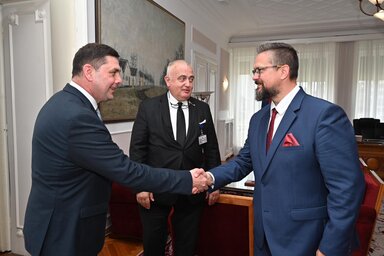 Juhász Bálint Gyülvészi Gyulát üdvözli, a háttérben Lukas Rasulić (Fotó: Tartományi parlament)