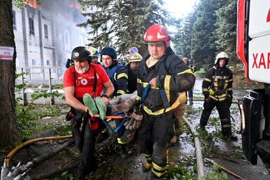 Mentők és tűzoltók egy sebesültet visznek biztonságos helyre a Harkivot ért orosz támadás után (rnz.co.nz)