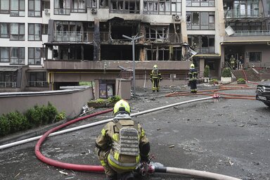 Tűzoltók egy megrongálódott lakóépület előtt Kijevben (Fotó: AP via Beta)
