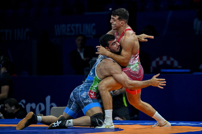 Losonczi Dávid (pirosban) térde épp Komarov későbbi ellenfele, az iráni Mohmadipiani (kékben) ellen sérült meg (Fotó: MTI)