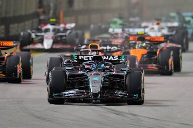 George Russell vezeti a mezőnyt a szingapúri éjszakában, mögötte a McLaren és Verstappen üldözik (Fotó: Beta/AP)