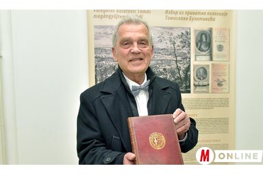 Bulatović Tamás egy olyan könyvvel a kezében, amelynek borítója Savoyai Jenő könyvtárából származik (Gergely Árpád felvétele)