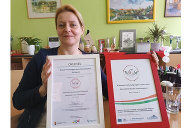 Hangya Jurca Éva az első és a legutóbbi akkreditációról szóló igazolással/Fotó: Gruik Zsuzsa