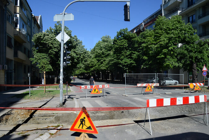 A Makszim Gorkij utcában már hosszú hónapok óta csatornáznak, szakaszosan, bosszantóan lassú tempóban. A legutóbbi munkaszakasz kezdetén az építkezési kerítéseket a május elsejei ünnepsort megelőző napon már kihelyezték, lezárták a forgalmat, de a munkagépek csak a hosszú hétvégét követően jelentek meg. Soha nem fogjuk megtudni, hogy kinek áll érdekében lezárva tartani ezt a különösen forgalmas utcát minél hosszabb ideig.