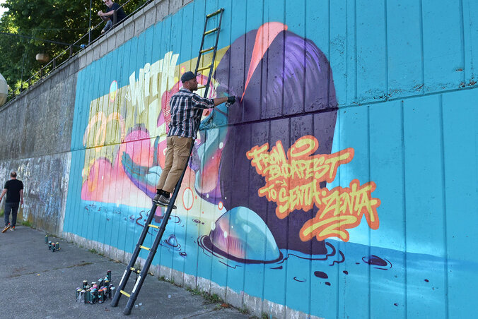 Az alsó rakpartot egykoron színes graffitik borították, de az évek alatt kifakultak; tavaly egy külföldi művész lefestette a zentai látványosságokat, idén pedig egy újabb művel bővült a szabadtéri fali kiállítás