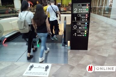A Promenada bevásárlóközpontban minden megtesznek annak érdekében, hogy meggátolják a koronavírus terjedését. A pláza beltere egyébként is különösen tágas, hatalmas mennyiségű levegő van benn. A mozgólépcsők elé a két méteres távolságtartásra figyelmeztető matricákat ragasztottak. Valóban mindegyik alkalmazott, biztonsági őr és pincér szájmaszkot visel, a látogatok körében viszont csak elvétve látunk maszkot. A pláza vezetősége tehát mindent megtett a biztonság érdekében, a többi már tőlünk függ (Szeli Balázs felvétele)