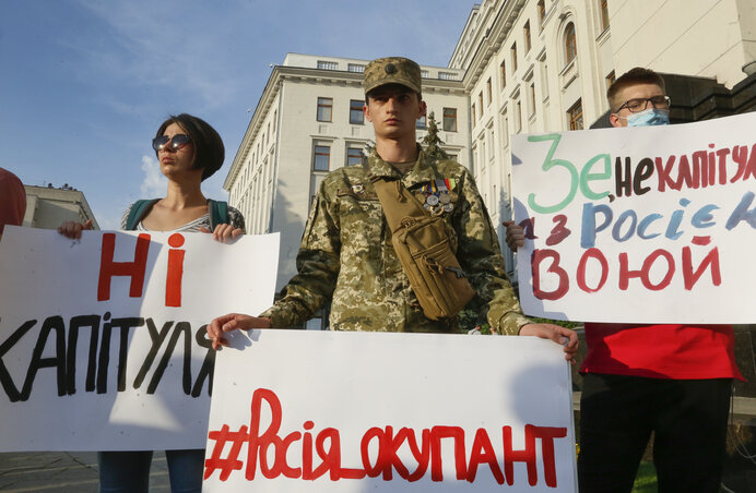 A fegyverszünetre válaszul aktivisták és katonák a „Nem adjuk meg magunkat” és „Oroszország megszálló” feliratú molinókkal tüntettek tegnap a kijevi kormányfői hivatal előtt (Fotó: AP via Beta)