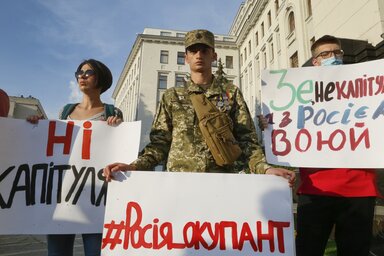 A fegyverszünetre válaszul aktivisták és katonák a „Nem adjuk meg magunkat” és „Oroszország megszálló” feliratú molinókkal tüntettek tegnap a kijevi kormányfői hivatal előtt (Fotó: AP via Beta)