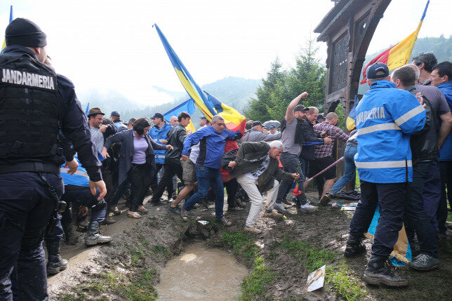 A román ellentüntetők a kaput betörve beözönlenek a katonatemető területére (Fotó: MTI)