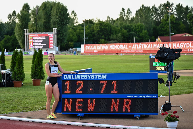 Kozák Luca a nemzeti csúcsát mutató jelzőtáblával