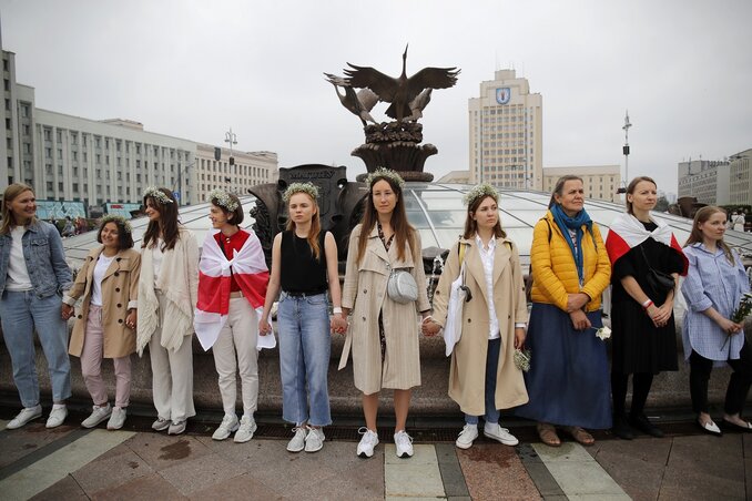 Hölgyek egymás kezét fogva élőláncot formáltak az egyik minszki emlékmű előtt (Fotó: Beta)