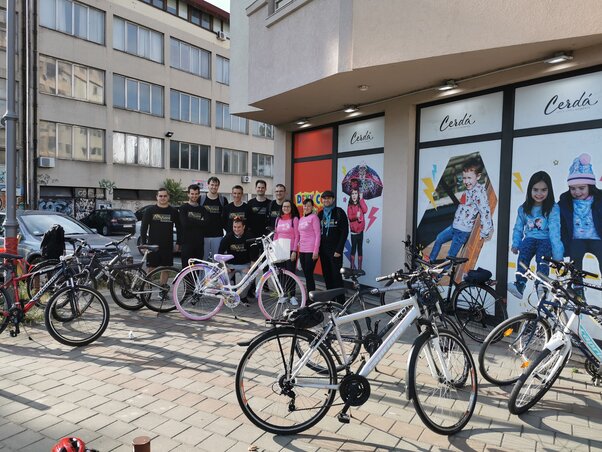 A lelkes csapat indulás előtt, a rózsaszín kerékpárral