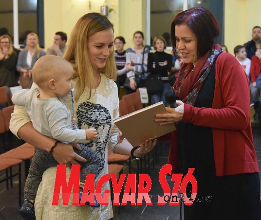Vicsek Annamária, az Újvidéki Magyar Oktatásért projekt vezetője átadja az Első könyvem című kiadványt (Ótos András felvétele)