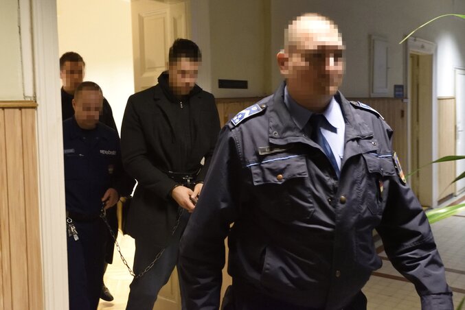 Rendőrök vezetik el a barátnője megölésével gyanúsított 29 éves gunarasi fiút a Szegedi Járásbíróság folyosóján (Fotó: MTI)