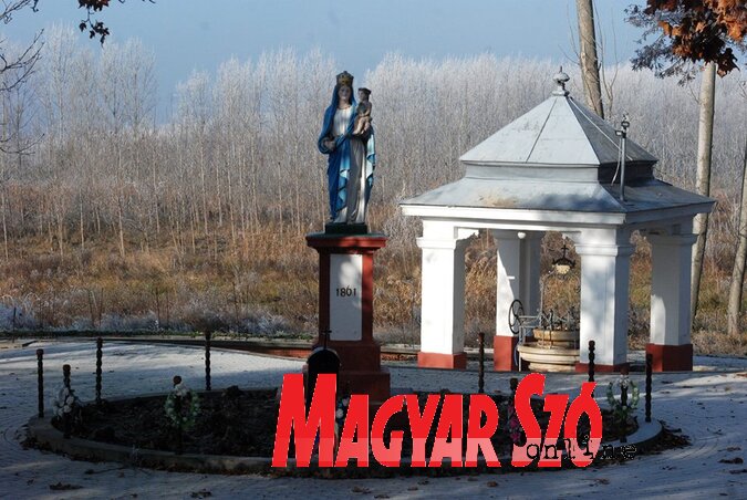 Szűz Mária-kegyszobor a kúttal a háttérben (Gellér Ágnes fotója) Szűz Mária-kegyszobor a kúttal a háttérben (Gellér Ágnes fotója)