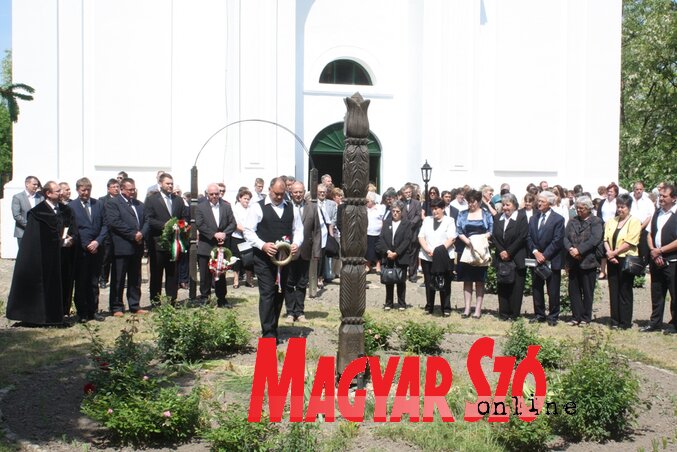 Az ünneplő gyülekezet megkoszorúzta a templomkertben felállított kopjafát (Fotó: Kazinczy Paszterkó Diana)