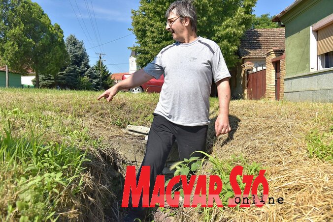 Kovács Ervin a háza előtt derékig érő vízmosta gödörben (Gergely József felvétele) Kovács Ervin a háza előtt derékig érő vízmosta gödörben (Gergely József felvétele)