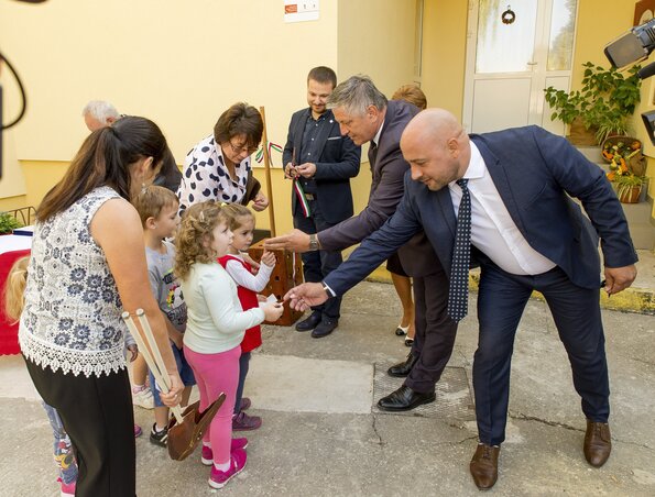 Grezsa István (balról) és Menyhárt József, a felvidéki Magyar Közösség Pártjának (MKP) elnöke a nemzeti színű avatószalag darabjait adják át az óvodásoknak a Gelléren felújított óvodaátadási ünnepségén (fotó: MTI)