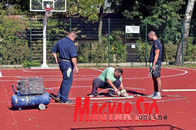 A palicsi sportközpont kosárlabdapályáján a csíkok felfestése folyik (Gergely Árpád felvétele)