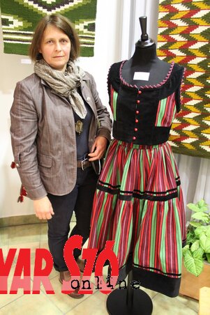Ágoston Andrea szövő, népi iparművész erdélyi, mezőpaniti viselete mellett, melyet ő szőtt (Szabó Nóra felvétele)