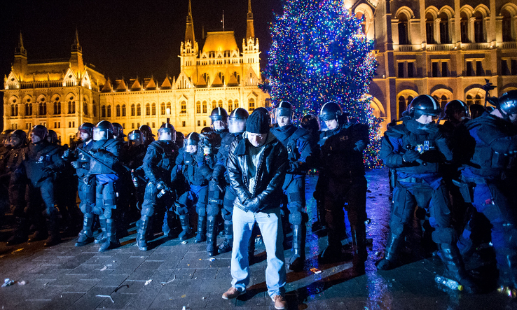 Rendőrök kiszorítják az ellenzéki pártok kezdeményezésére a munka törvénykönyvének módosítása ellen indult tüntetés résztvevőit a Parlament előtti Kossuth téren (Fotó: MTI/Balogh Zoltán)