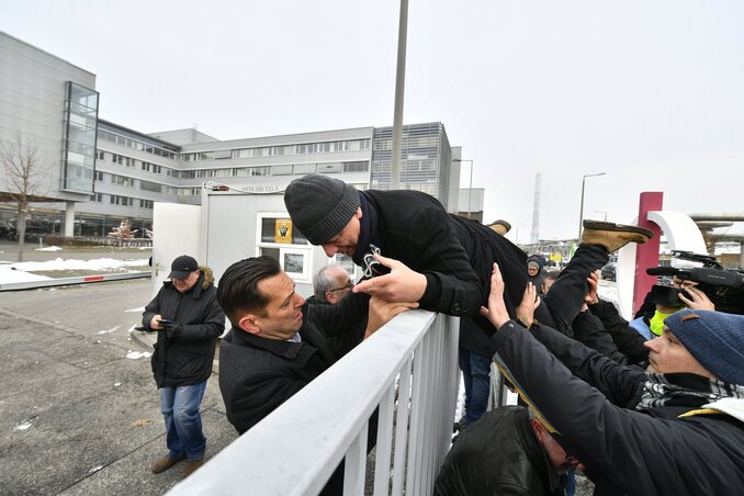 Gréczy Zsoltot, a DK országgyűlési képviselőjét átsegítik a székház kerítésén (fotó: MTI)
