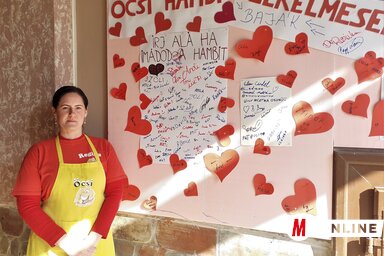 Dévity Regina az Öcsi hamburgerező Valentin-napi pannója mellett (Kazinczy Paszterkó Diana felvétele)