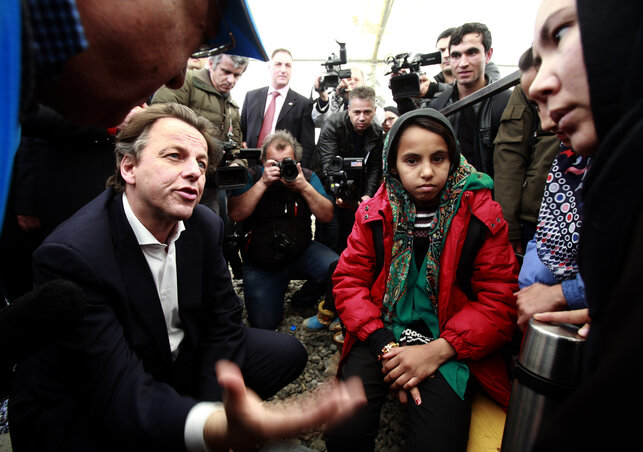 Bert Koenders holland külügyminiszter afgán menekültekkel beszélget Gyevgyelijában (Fotó: Beta/AP)