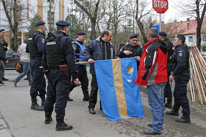Rendőrök a tüntetésen eltávolíttatják a székely zászló hegyes rúdvégződését (Fotó: MTI)