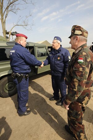 Halmosi Zsolt és Benkő Tibor (jobbról) egy rendőrrel beszélget a szerb–magyar határnál tett látogatásuk során (Fotó: MTI)